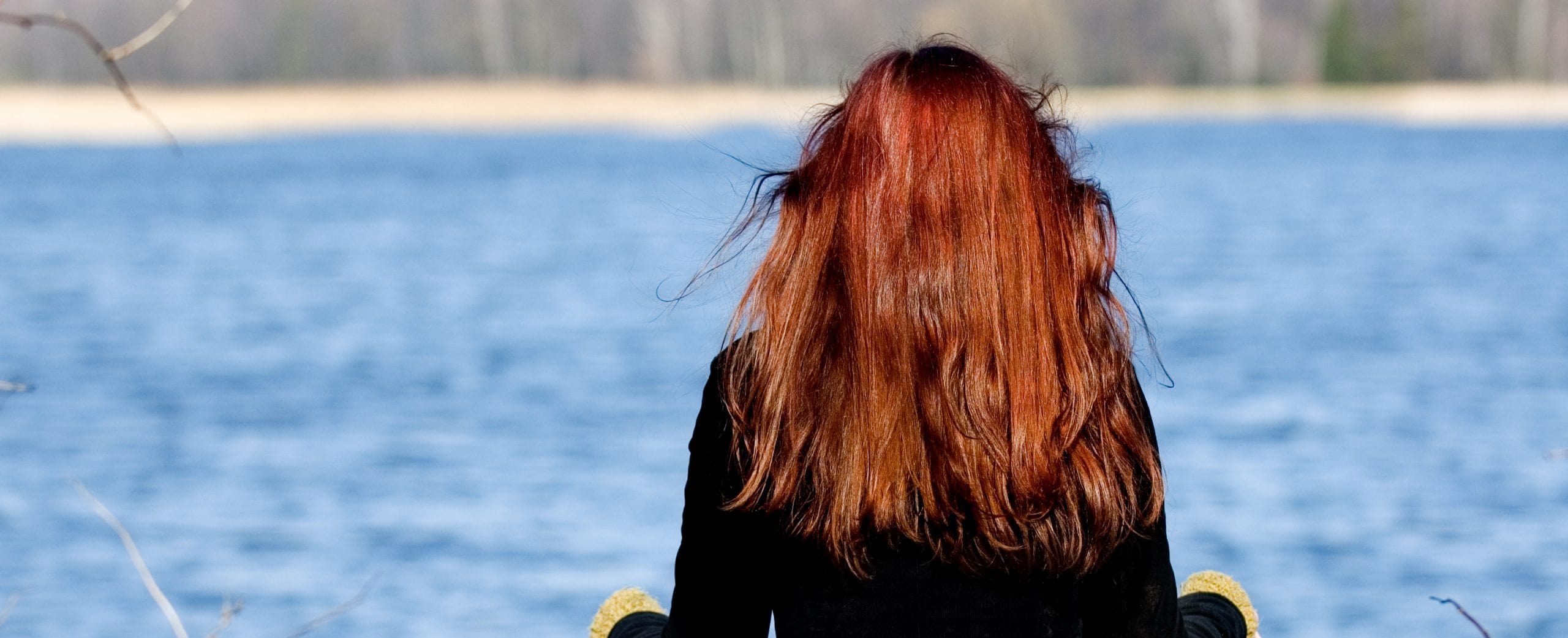 A woman resting peacefully beside a lake